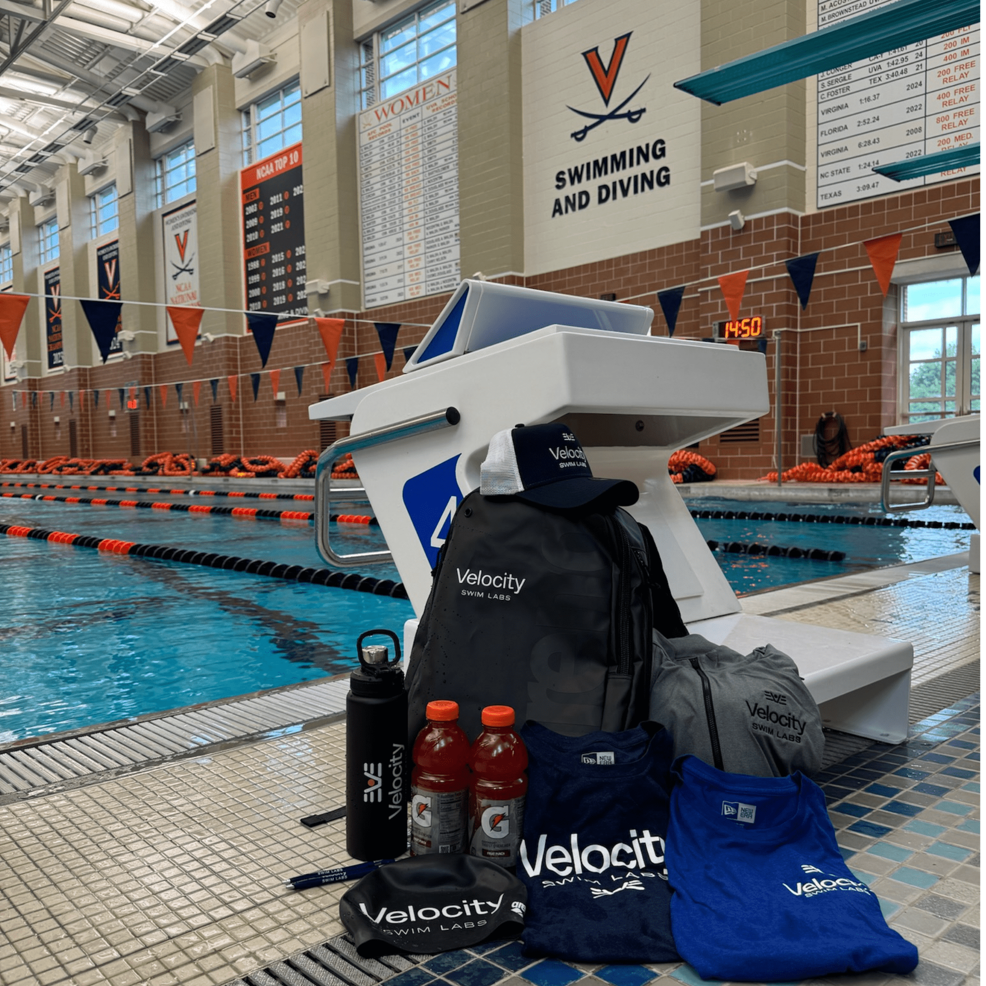 Velocity Swim Labs merchandise and equipment display including branded bags and bottles