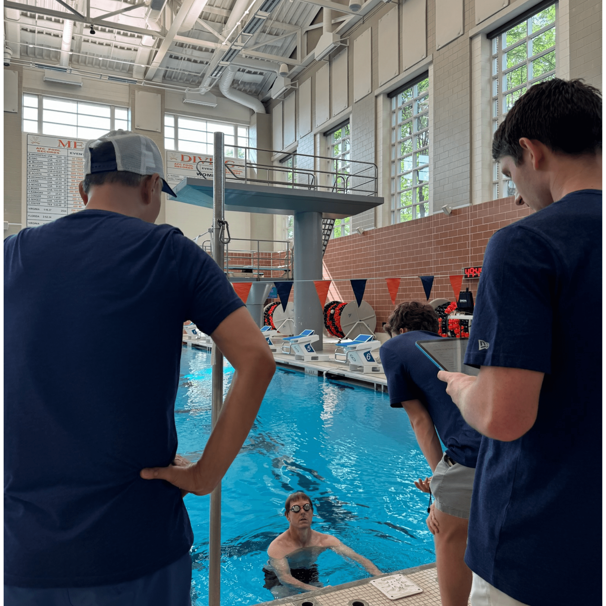 Team testing swimmer with advanced technology and poolside analysis